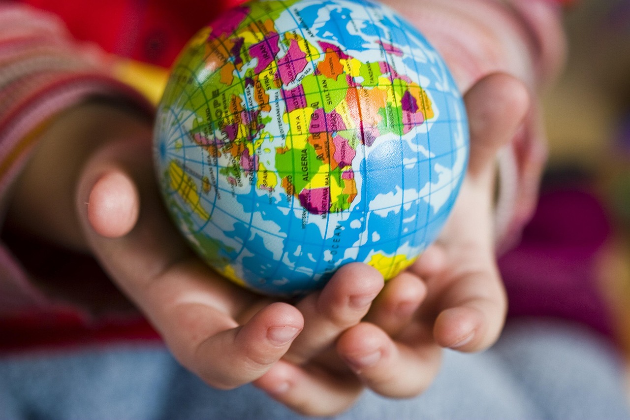 Child holding a small globe in cupped hands